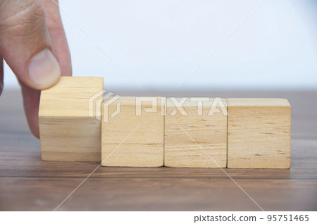 Hand turning blank wooden cubes customizable space for text or ideas. 95751465