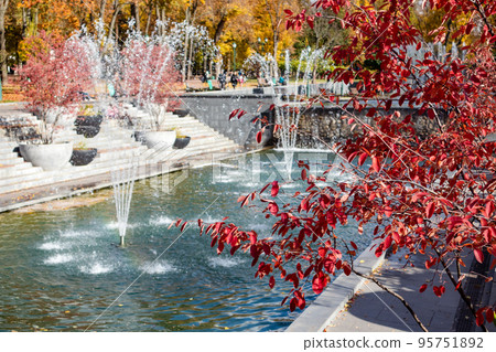Fountains in Kharkiv city with red autumn trees Fountains in Kharkiv city with red autumn trees 95751892