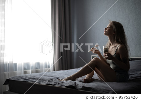 Girl sitting in bed and enjoying chia pudding Girl sitting in bed and enjoying chia pudding 95752420