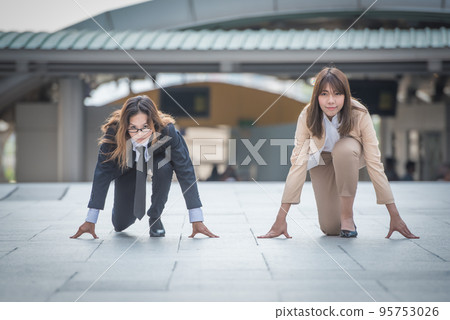 2023 new start, two business woman getting ready for race in business on the city background, business competition concepts. 95753026