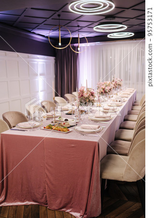 Elegant decoration of the table in restaurant. Pink tablecloth stylish cutlery and beautiful flowers Elegant decoration of the table in restaurant. Pink tablecloth stylish cutlery and beautiful flowers 95753171