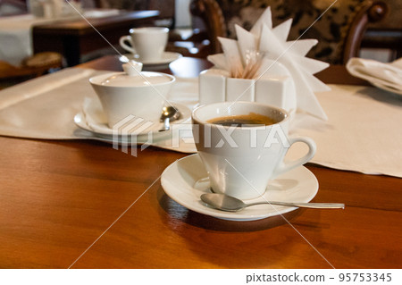Cup with coffee on the serving table Cup with coffee on the serving table 95753345