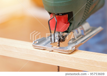The hands of a master carpenter with an electric The hands of a master carpenter with an electric 95753609