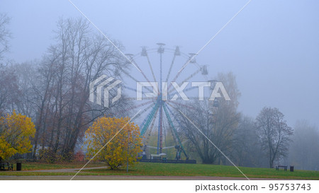 Ferris wheel in an old abandoned park in autumn in thick fog. There are no people in the park Ferris wheel in an old abandoned park in autumn in thick fog. There are no people in the park 95753743