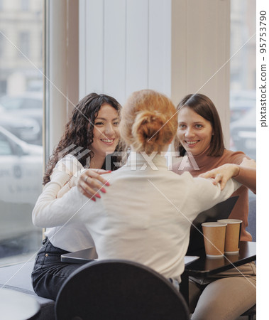 three female friends are talking in a coffee shop and drinking tea, moral support and caring friendship. mental health 95753790