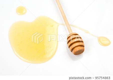spoon with fresh honey spilled on a white background. organic vitamin food spoon with fresh honey spilled on a white background. organic vitamin food 95754863