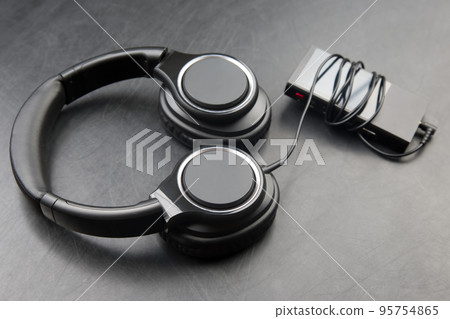 Headphones for listening to music with digital audio player on dark background 95754865