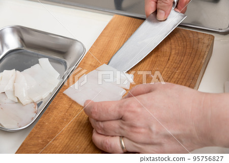 [A middle-aged housewife prepares a Japanese flying squid and moves the cut body to the bat] 95756827