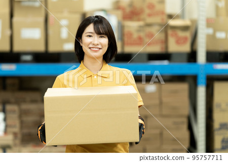女員工在倉庫搬運紙箱 95757711