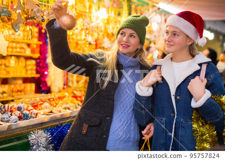 Mother and daughter choosing christmas decorations 95757824