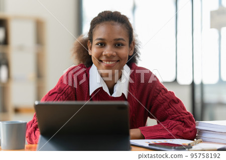 Portrait of beautiful young black woman using digital tablet. 95758192