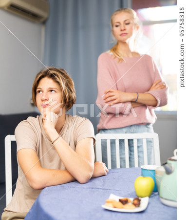 Portrait of unhappy son after discord with mother Portrait of unhappy son after discord with mother 95758318