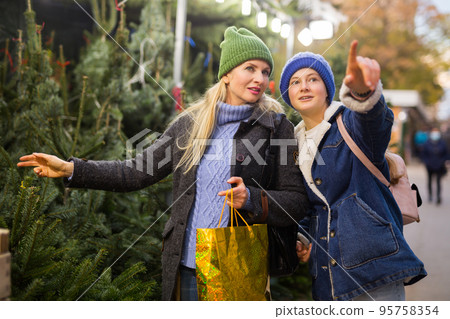 Mother and daughter choosing christmas tree 95758354