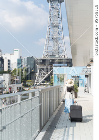 一名年輕女子拉著行李箱在名古屋觀光的背影 95758519