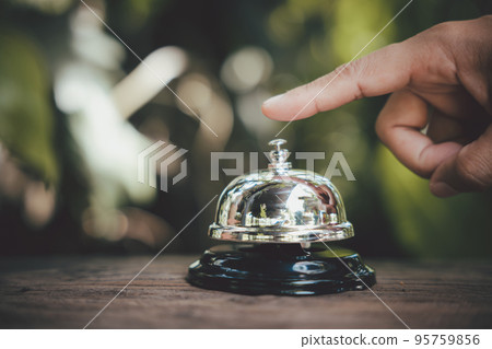Hospitality hotel. Customer hand ringing service bell at coffee cafe shop for calling the staff to receive the menu, Woman finger touching to ring bell 95759856