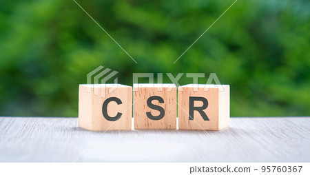 CSR, letters on wood block cube with green nature background. CSR, letters on wood block cube with green nature background. 95760367