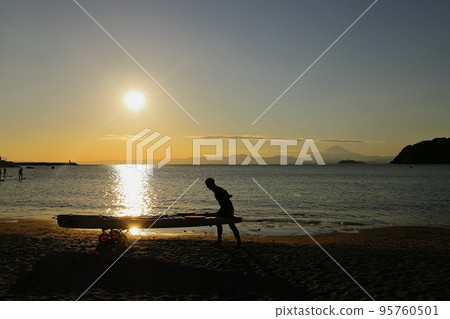 黃昏的祖師海岸，一個背著皮划艇的年輕人的剪影 95760501