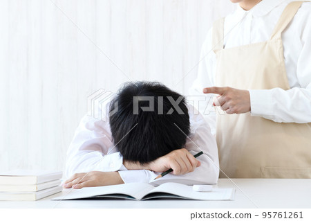 A child who puts his head down on the desk and a mother who scolds A child who puts his head down on the desk and a mother who scolds 95761261