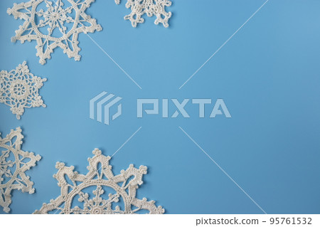 Top view of handmade white crochet snowflakes on blue background. Merry Christmas and happy new year concept. Top view of handmade white crochet snowflakes on blue background. Merry Christmas and happy new year concept. 95761532