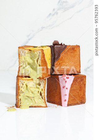 Sliced cube croissant with pistachio cream and whole cubes with berry icing and chocolate ganache Sliced cube croissant with pistachio cream and whole cubes with berry icing and chocolate ganache 95762393