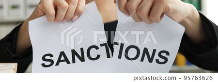 Person tore up document with words of sanction Person tore up document with words of sanction 95763626