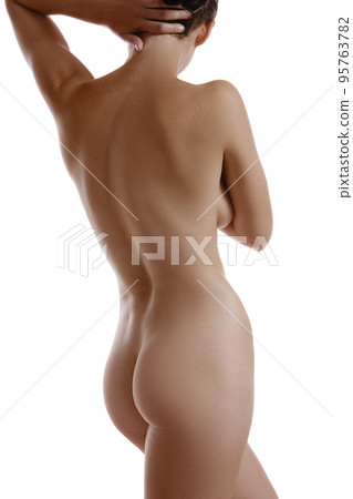 Nude woman covering her breast with hands, posing standing back to camera, isolated on white. Plastic surgery and aesthetic cosmetology. Close-up. 95763782
