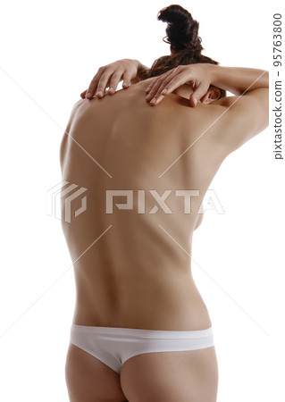 Woman in panties touching her spine, posing standing back to the camera, isolated on white. Plastic surgery, aesthetic cosmetology concept. Close-up. Woman in panties touching her spine, posing standing back to the camera, isolated on white. Plastic surgery, aesthetic cosmetology concept. Close-up. 95763800