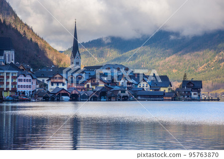 Hallstatt, a charming village on the Hallstattersee lake and a famous tourist attraction, with beautiful mountains surrounding it, in Salzkammergut region, Austria, in winter sunny day. 95763870