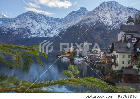 Hallstatt, a charming village on the Hallstattersee lake and a famous tourist attraction, with beautiful mountains surrounding it, in Salzkammergut region, Austria, in winter sunny day. Hallstatt, a charming village on the Hallstattersee lake and a famous tourist attraction, with beautiful mountains surrounding it, in Salzkammergut region, Austria, in winter sunny day. 95763886