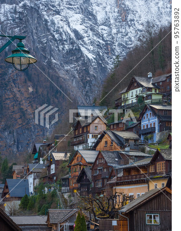 Hallstatt, a charming village on the Hallstattersee lake and a famous tourist attraction, with beautiful mountains surrounding it, in Salzkammergut region, Austria, in winter sunny day. 95763892