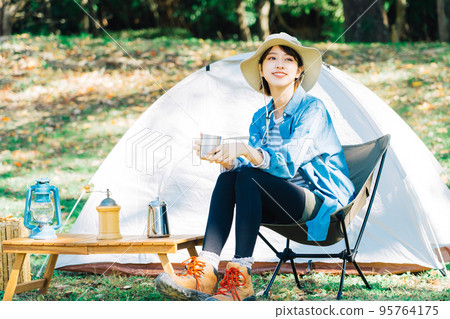 Young woman camping solo 95764175