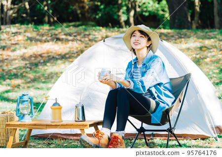 Young woman camping solo Young woman camping solo 95764176