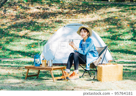 Young woman camping solo Young woman camping solo 95764181