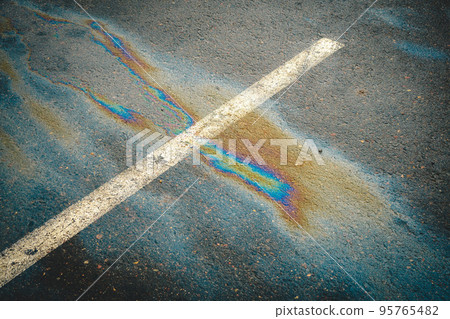 Oil spill on dark asphalt, parking lot with dividing lines. Oil spill on dark asphalt, parking lot with dividing lines. 95765482