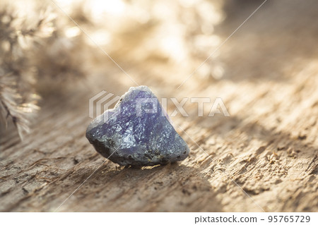 Rough Uncut Blue and Violet Tanzanite Gem on Wood 95765729