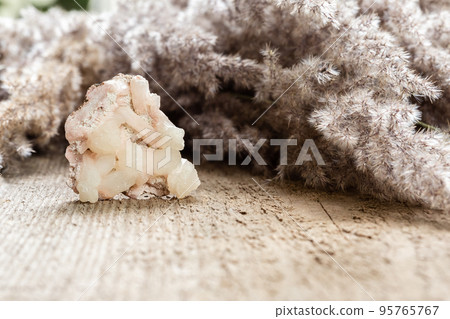 Raw Stilbite crystal sample on wood with copyspace Raw Stilbite crystal sample on wood with copyspace 95765767