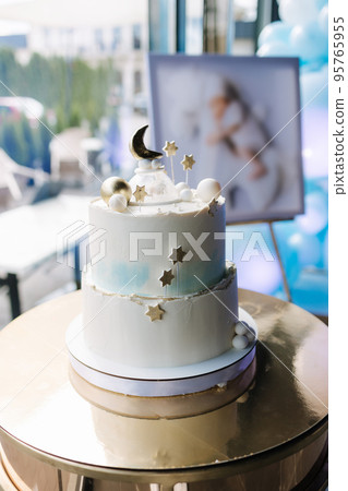 Beautiful cake for Christening. White cake decorated by stars from sugar. Gold stand Beautiful cake for Christening. White cake decorated by stars from sugar. Gold stand 95765955