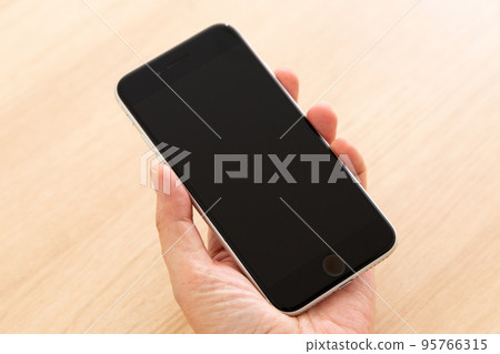 拿著智能手機的中間婦女的手 95766315