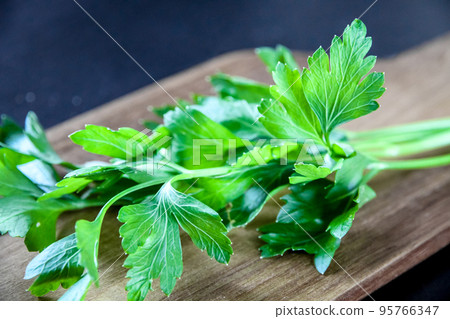 Bunch of parsley stem on a wooden cutting board 95766347