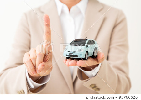 一位穿著西裝的中年婦女拿著汽車模型並舉起食指 95766620