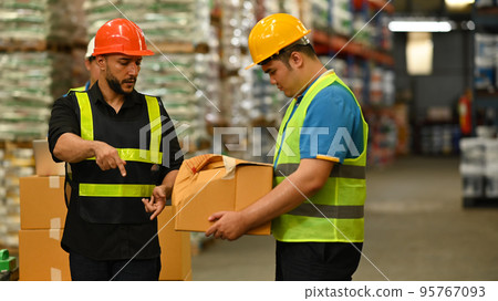 Irritated male manager expressing dissatisfaction with work of young intern in warehouse . Stress at work concept 95767093