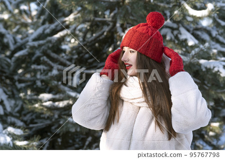 Beautiful brunette girl in red hat and mittens in winter outdoors. Little red riding hood 95767798