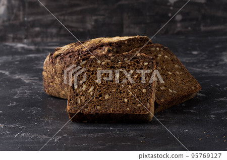 Rye bread on dark board background Rye bread on dark board background 95769127