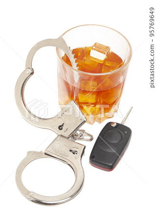 Concept for drinking and driving. Whiskey with car keys and handcuffs. 95769649