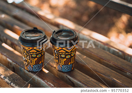 Background two glasses of takeaway coffee on wooden bench 95770352