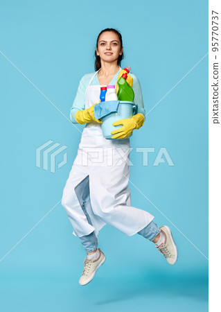 woman in gloves and cleaner apron with cleaning supplies 95770737
