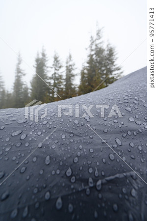 Raindrops on a blue tent close-up. Foggy morning in the Carpathians. Raindrops on a blue tent close-up. Foggy morning in the Carpathians. 95771413