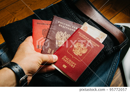 Russian documents and cash money are lying on a stick of things, the man is going to leave Russia. 95772057