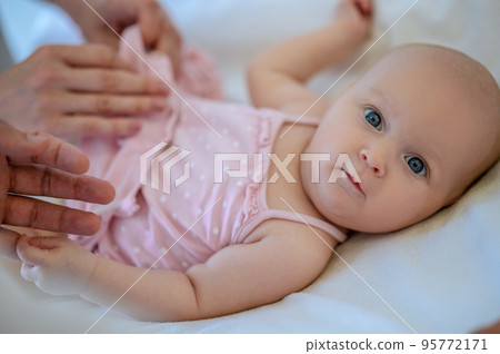 Surgeon checking babys legs for dysplasia Surgeon checking babys legs for dysplasia 95772171