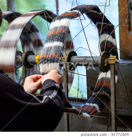 Threads dyed in various colors are rotated, inspected while being wound, and then shipped. 95772804